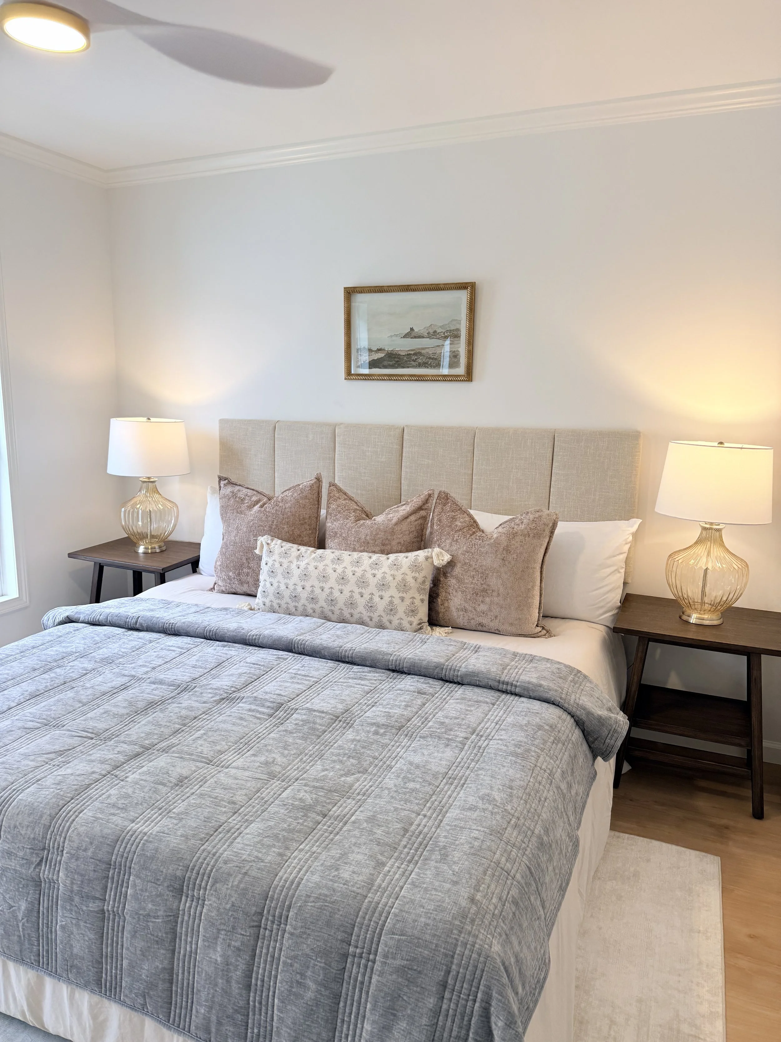 Photo of a bed with a small art hanging above it.