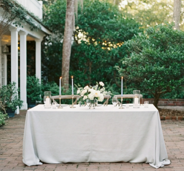 8 foot Rectangle table set for a meal outdoors with candles and a floral centerpiece.