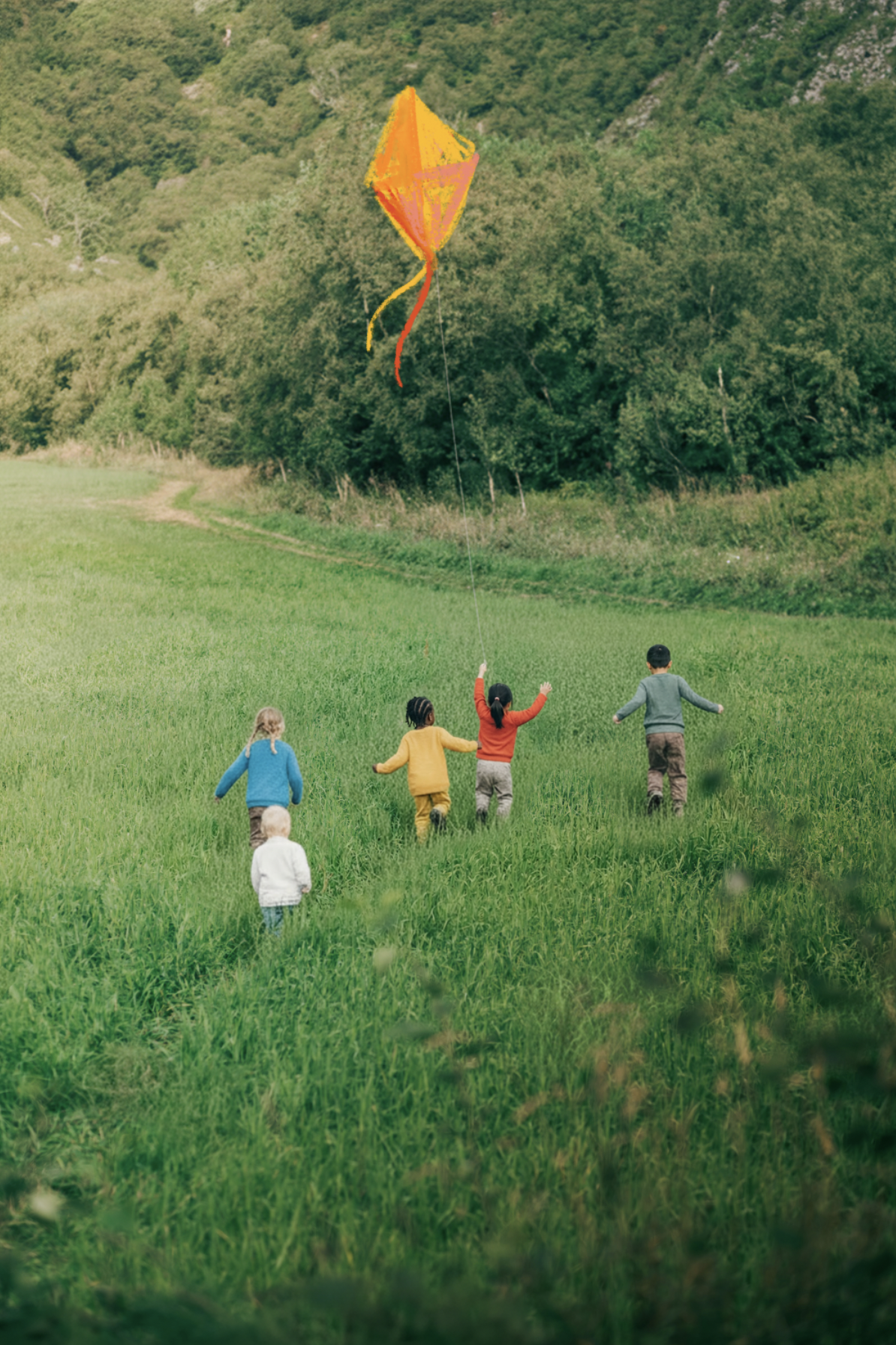 5 children of all different racial backgrounds playing in a green field. Each child is wearing a different brightly coloured shirt —white, blue, yellow, red,  and sage green. a orange and yellow crayon scribbled kite flies above them.