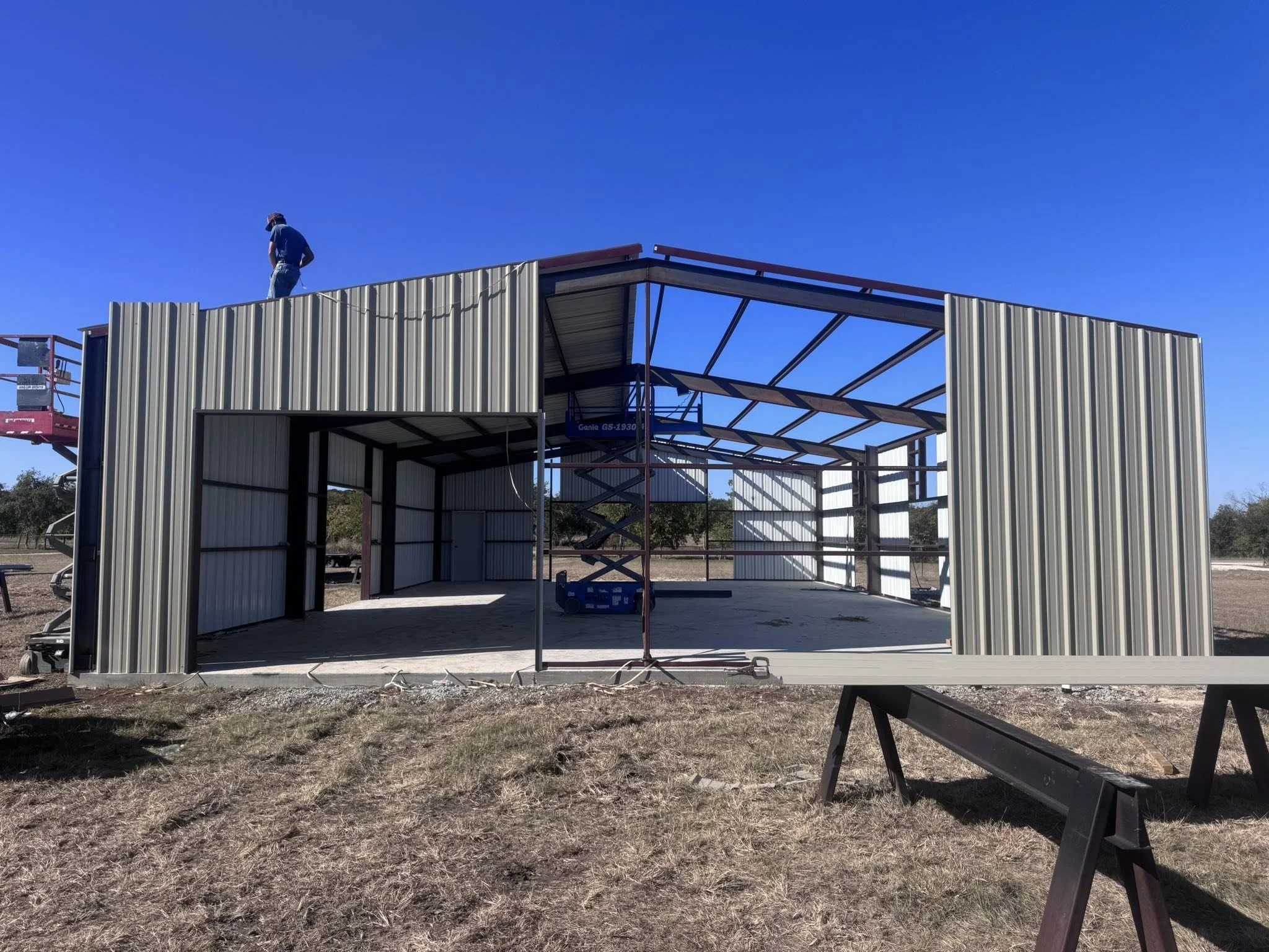 Construction of a metal storage shed with a wardrobe and open structure on a sunny day.