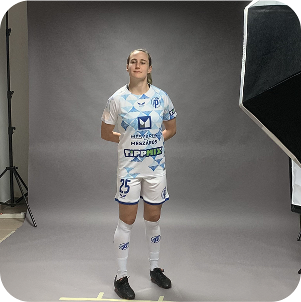 A female athlete in a white and blue sports uniform with the number 25, standing in a photo studio with a gray background.