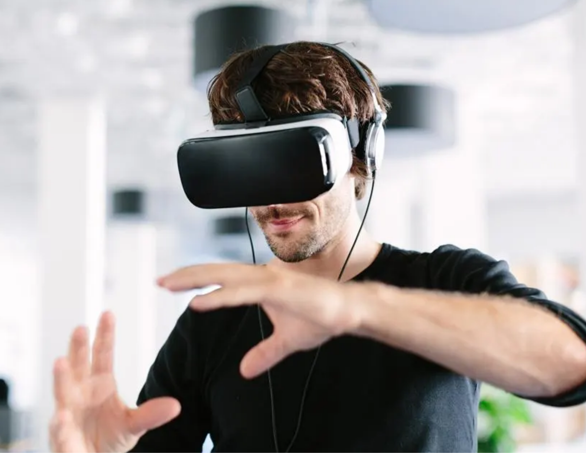 Man wearing a virtual reality headset and reaching forward with both hands