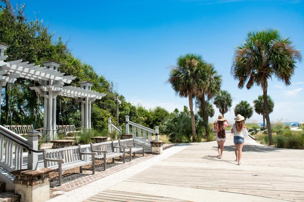 Two ladies walk down a boardwalk