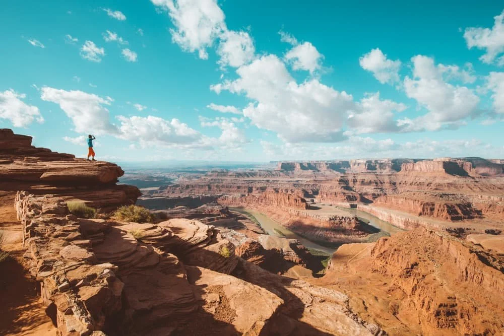 A hiker looks over a huge sweeping rocky valley