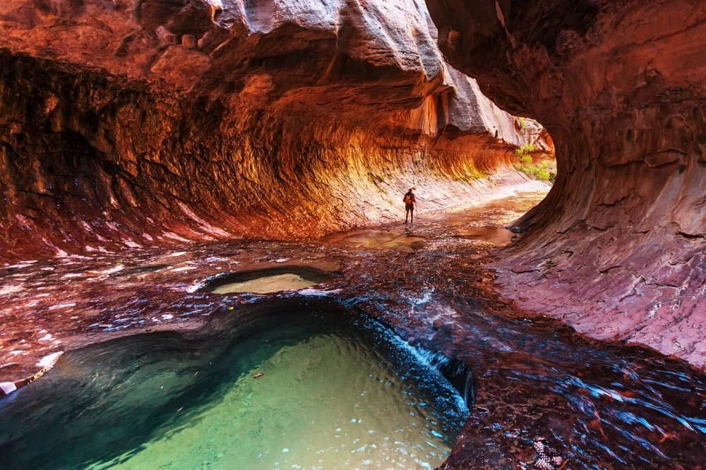A hiker in a canyon with red walls