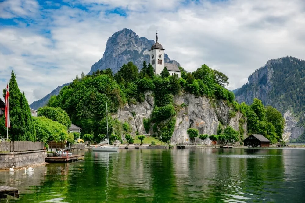 A chapel on top of a rock outcrop by a lake