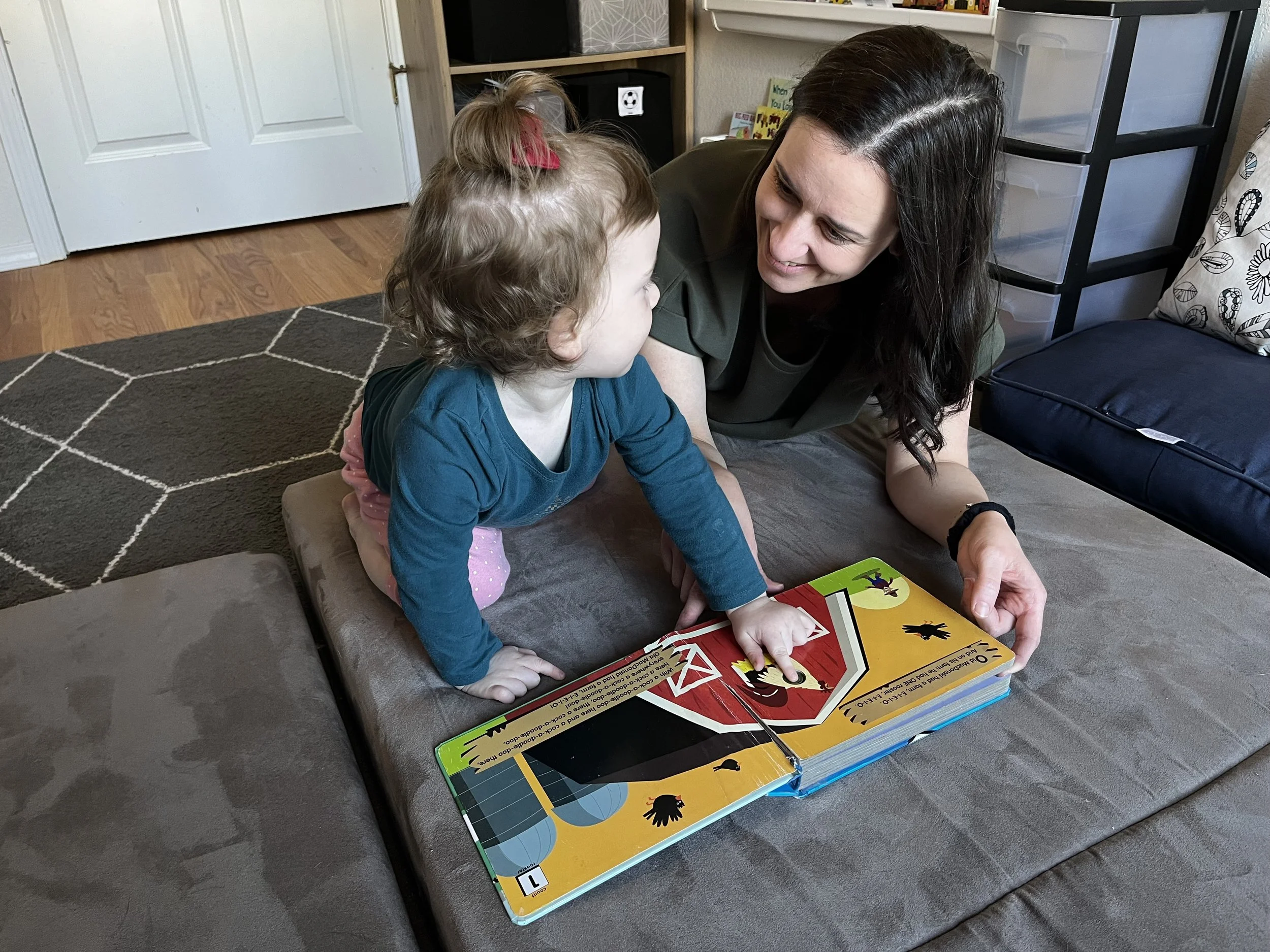 An occupational therapist reading a book with a toddler