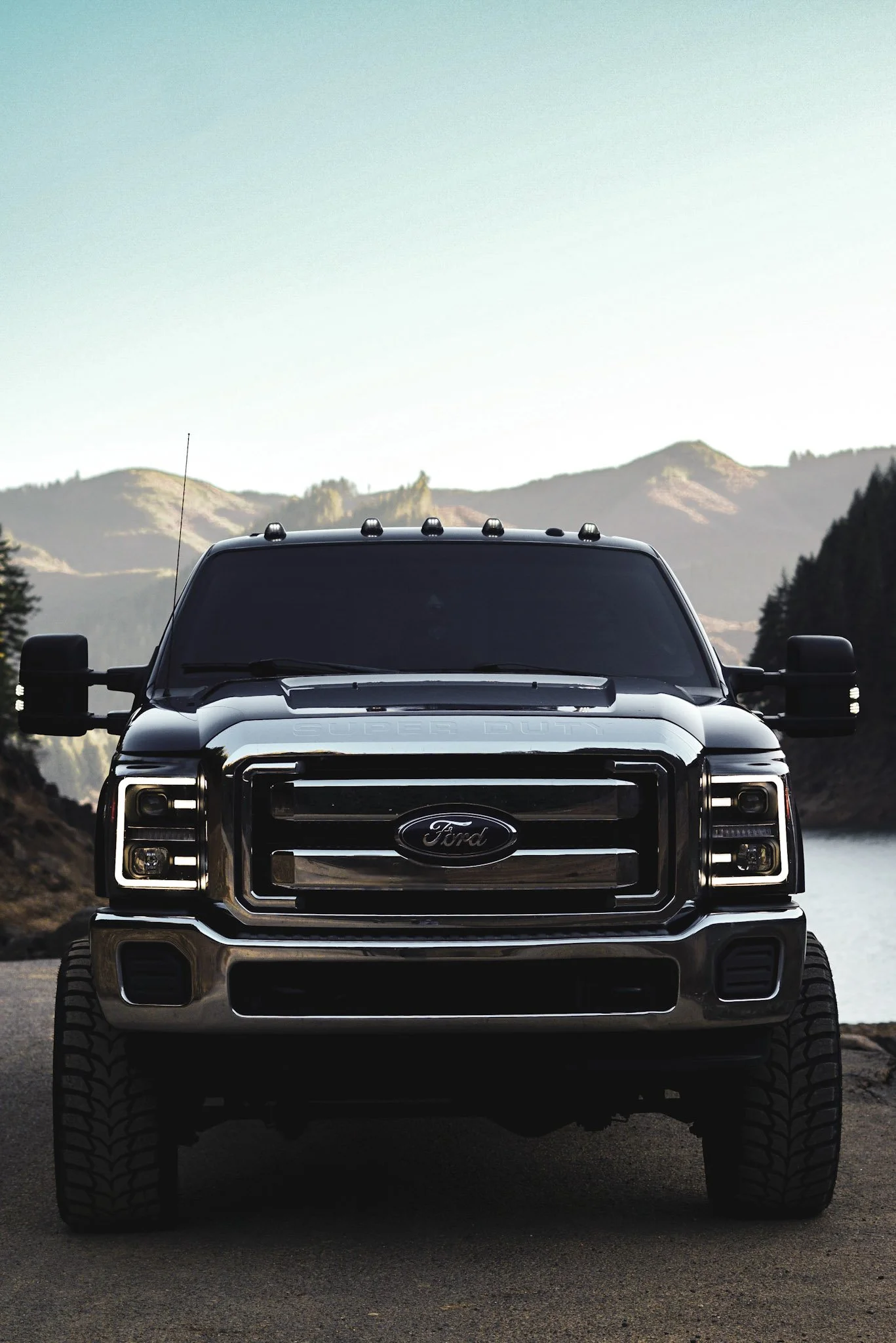 Front shot of Ford truck built out with mountains and lake in background