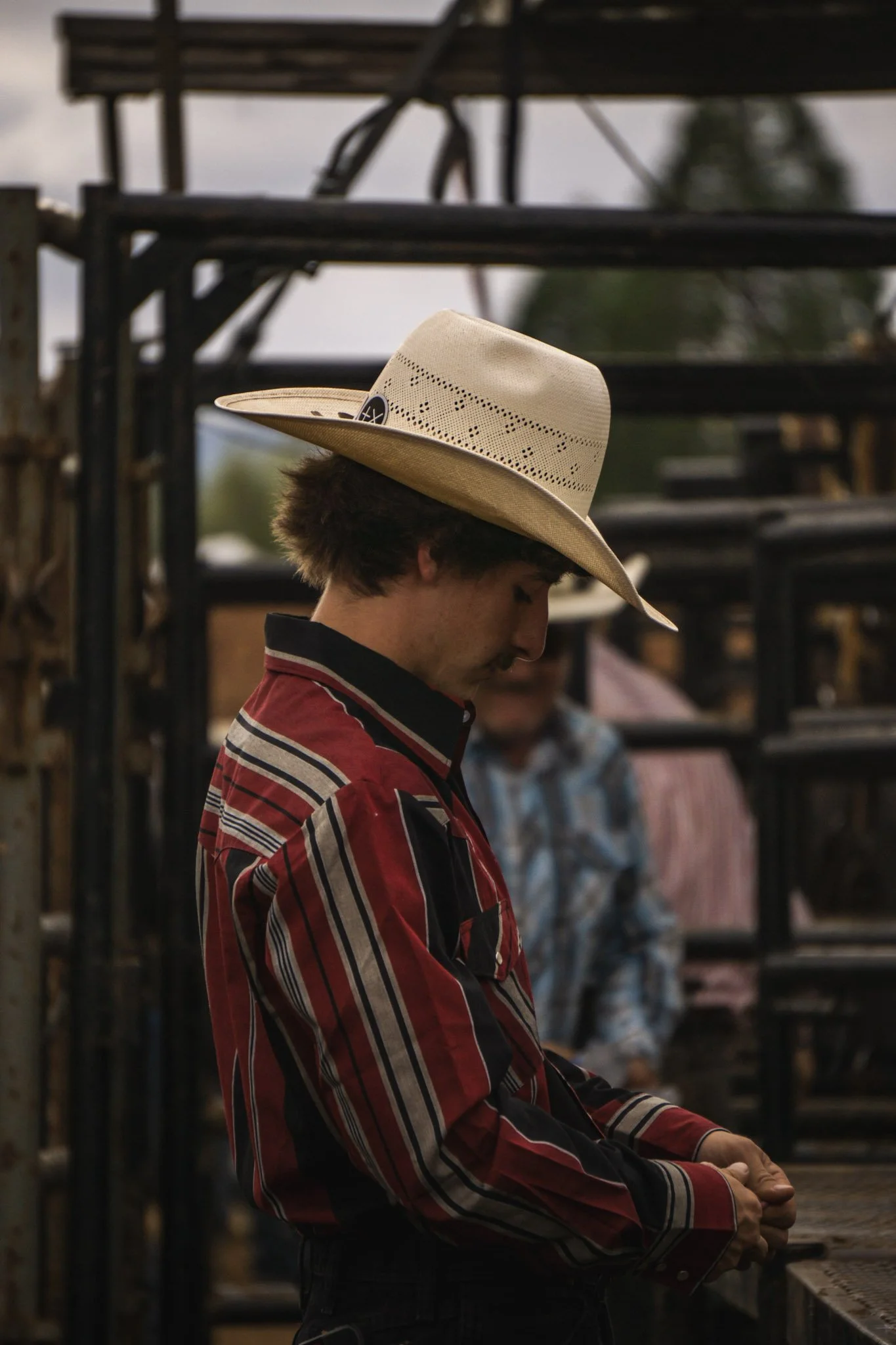 A cowboy wearing a hat tiring rope