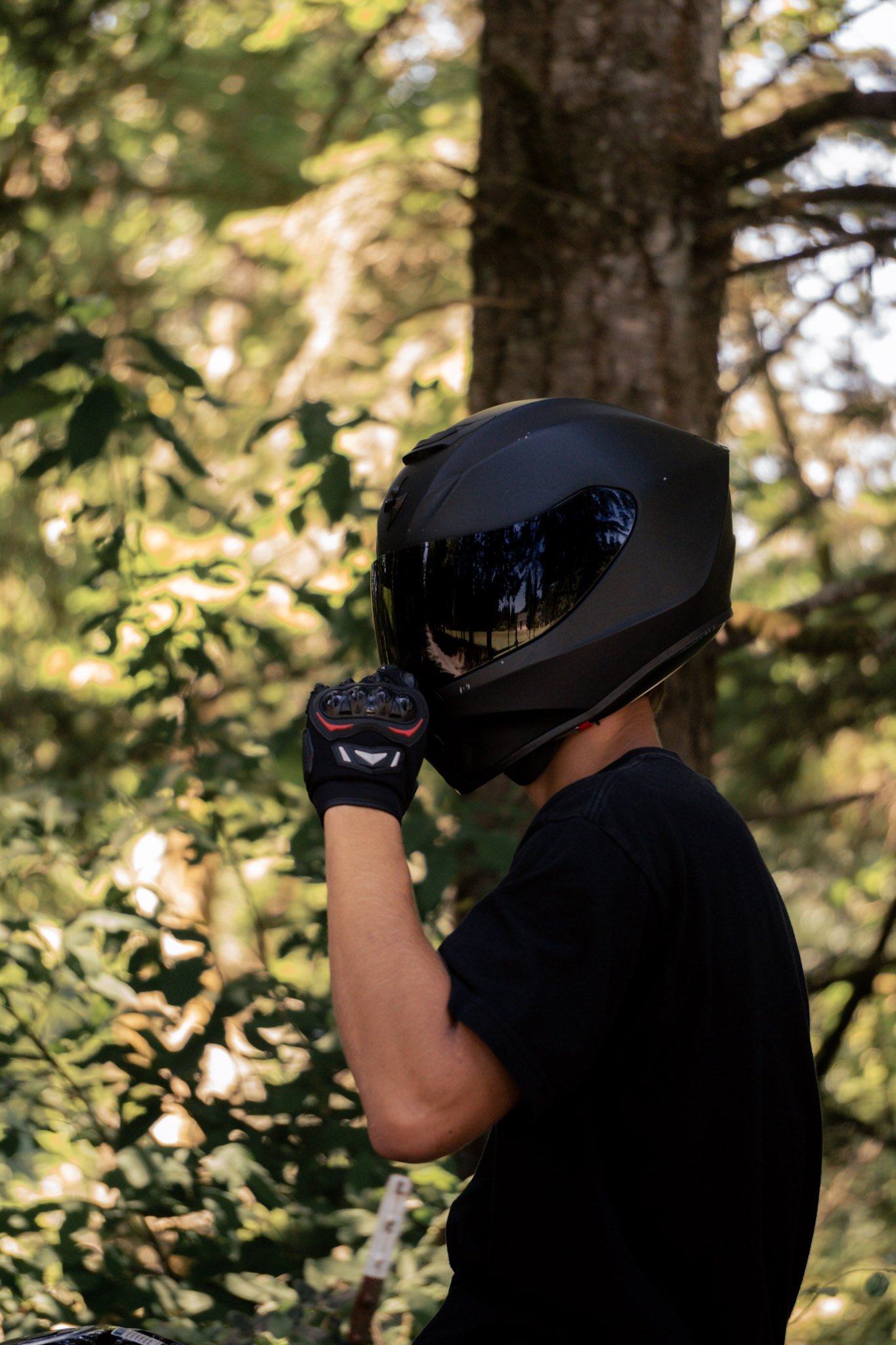 A biker flipping open his visor in the summer with tan skin