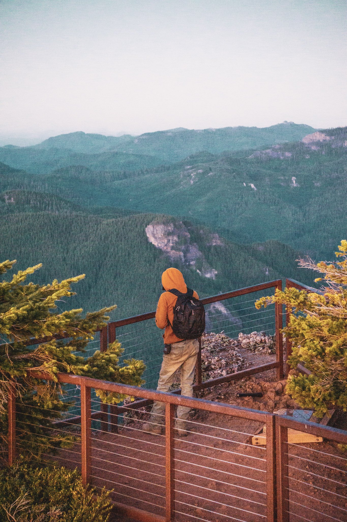 Hiker admiring views from top of mountain at sunrise