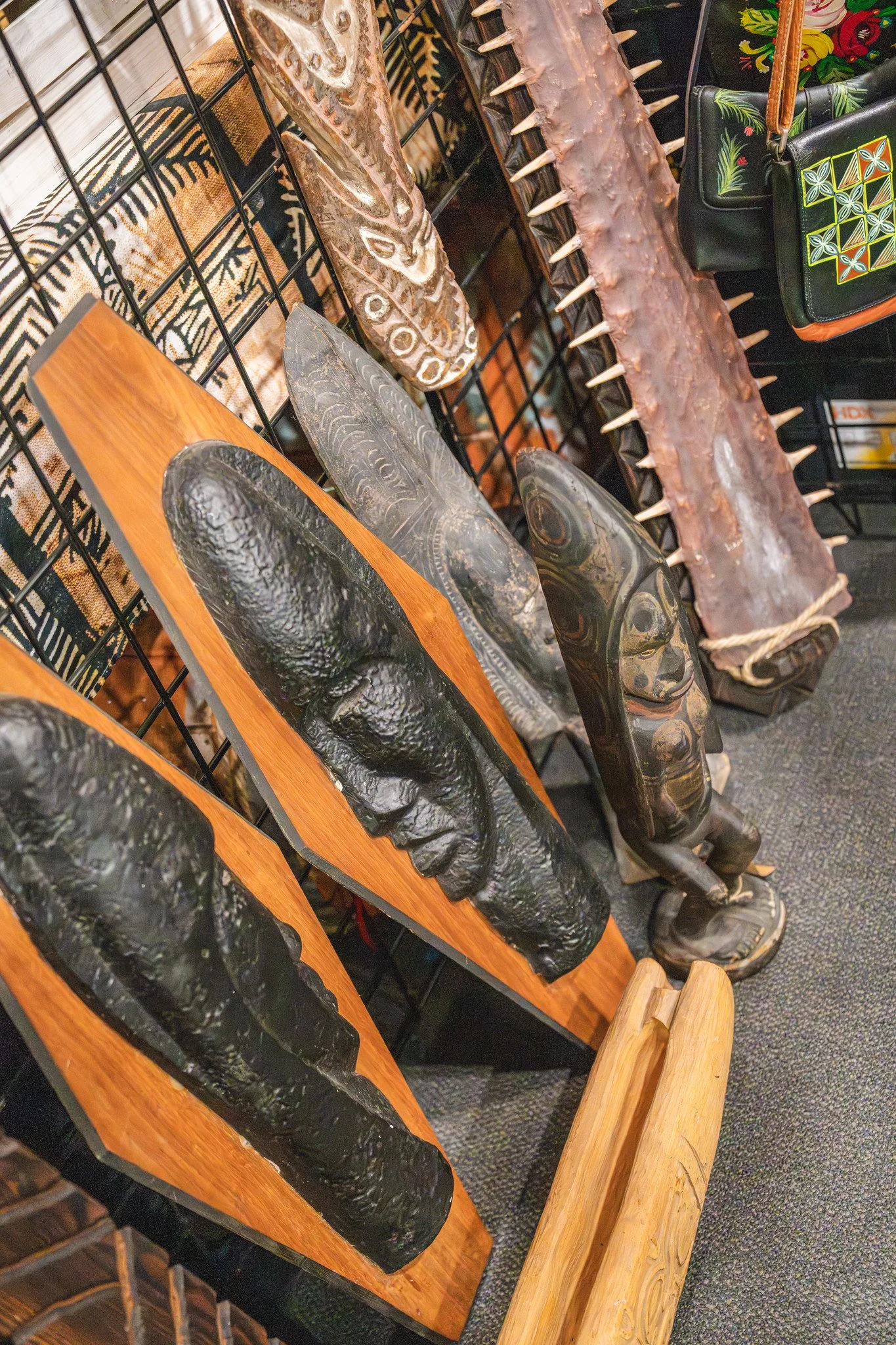 Display of carved stone masks and artifacts on a shopping rack.
