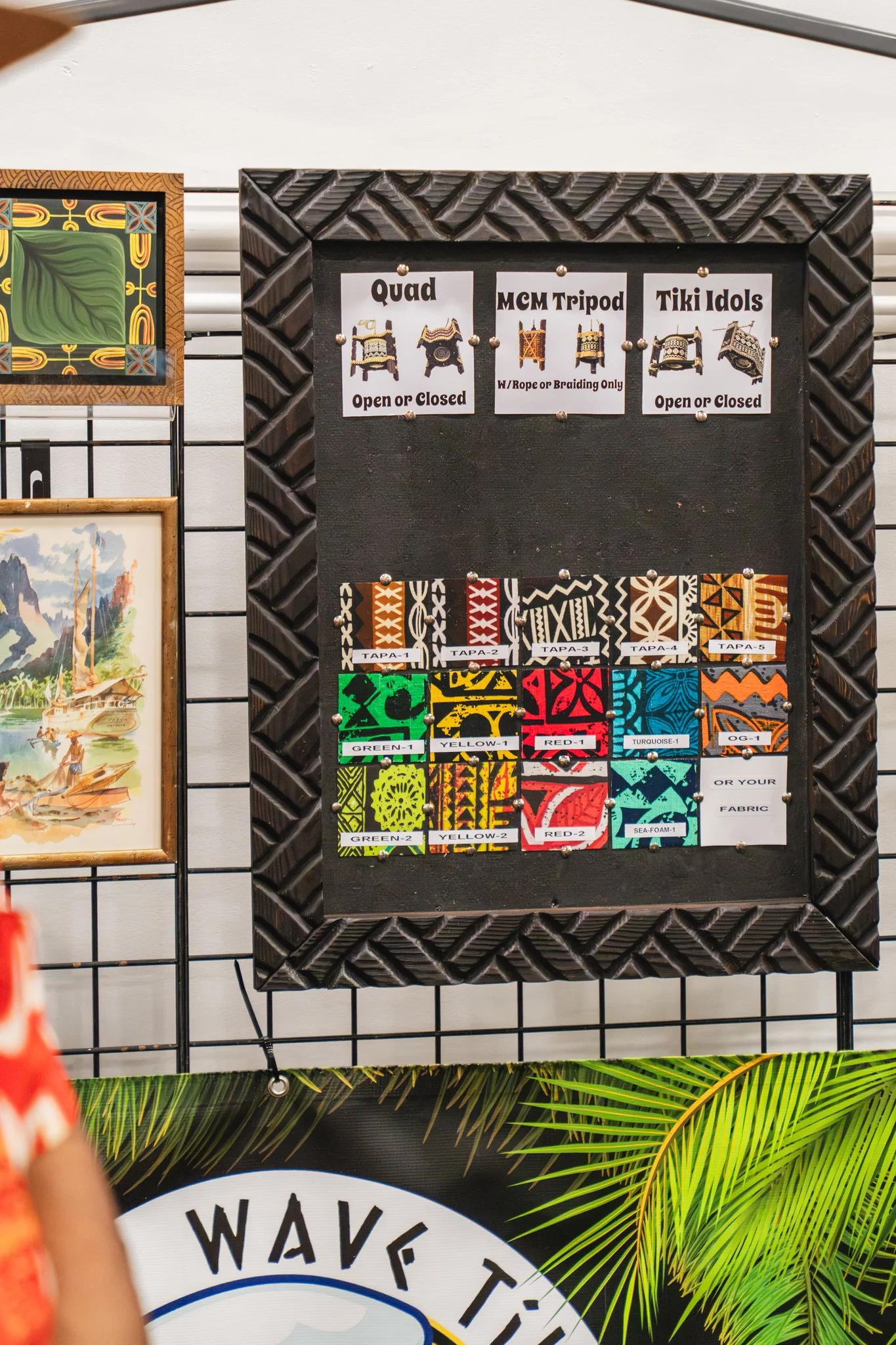 Display board with various colorful Hawaiian-themed fabrics and signs about traditional Polynesian drums, including Quad, MCM Tripod, and Tiki Idols.