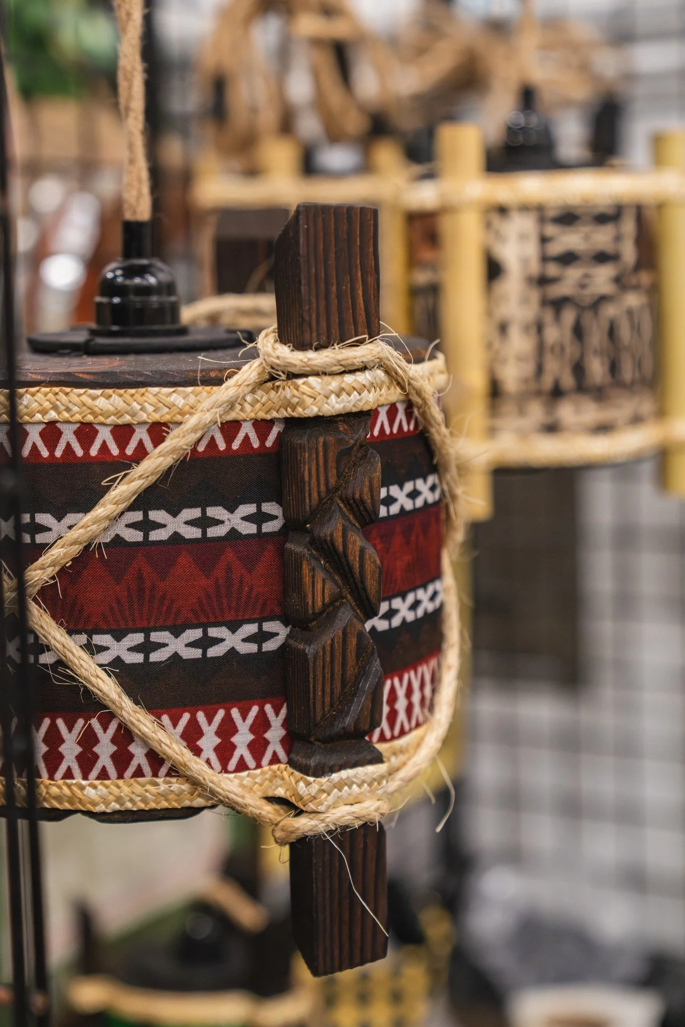 Close-up of a decorative wooden object with braided rope around it, part of a craft display.