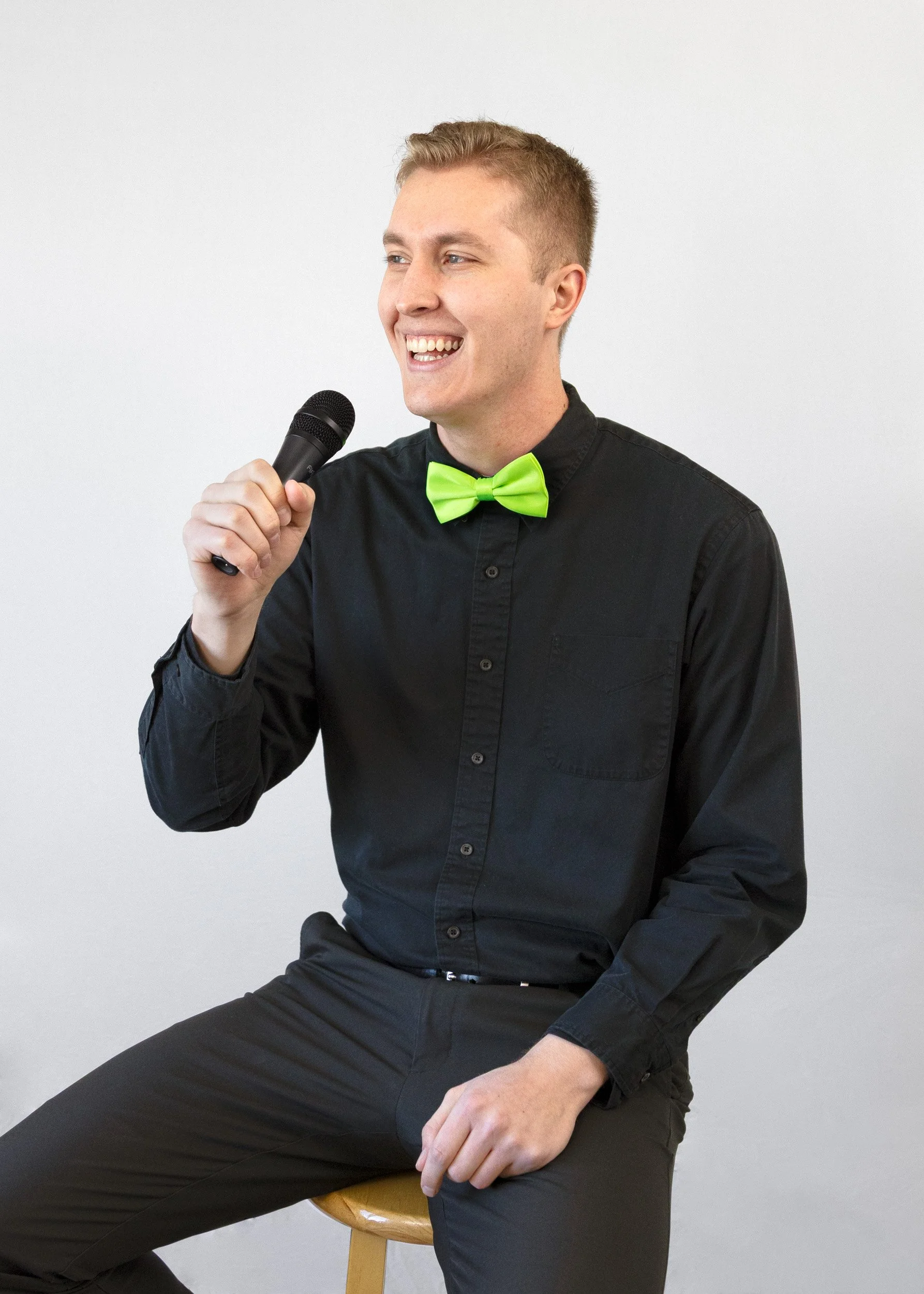 jarom smiling holding microphone black dress shirt green bowtie
