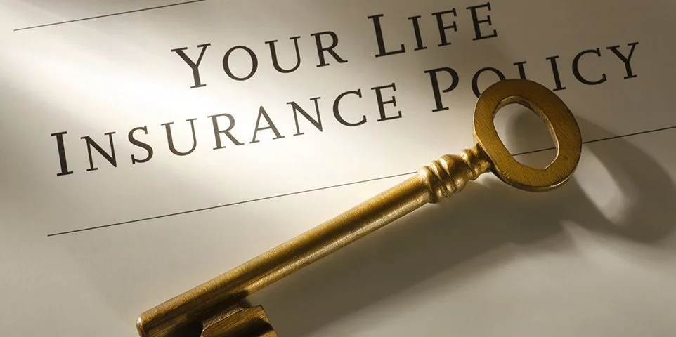 A gold key resting on a document titled 'Your Life Insurance Policy'.