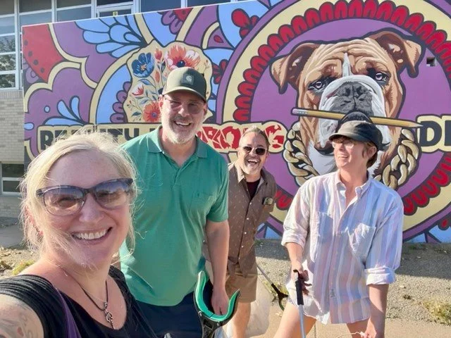 four people in front of a mural