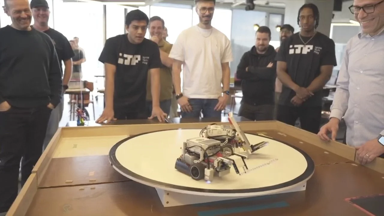 Teams watching a head-to-head robot battle