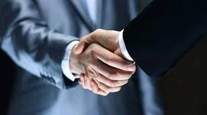 Close-up of two people shaking hands in a professional setting