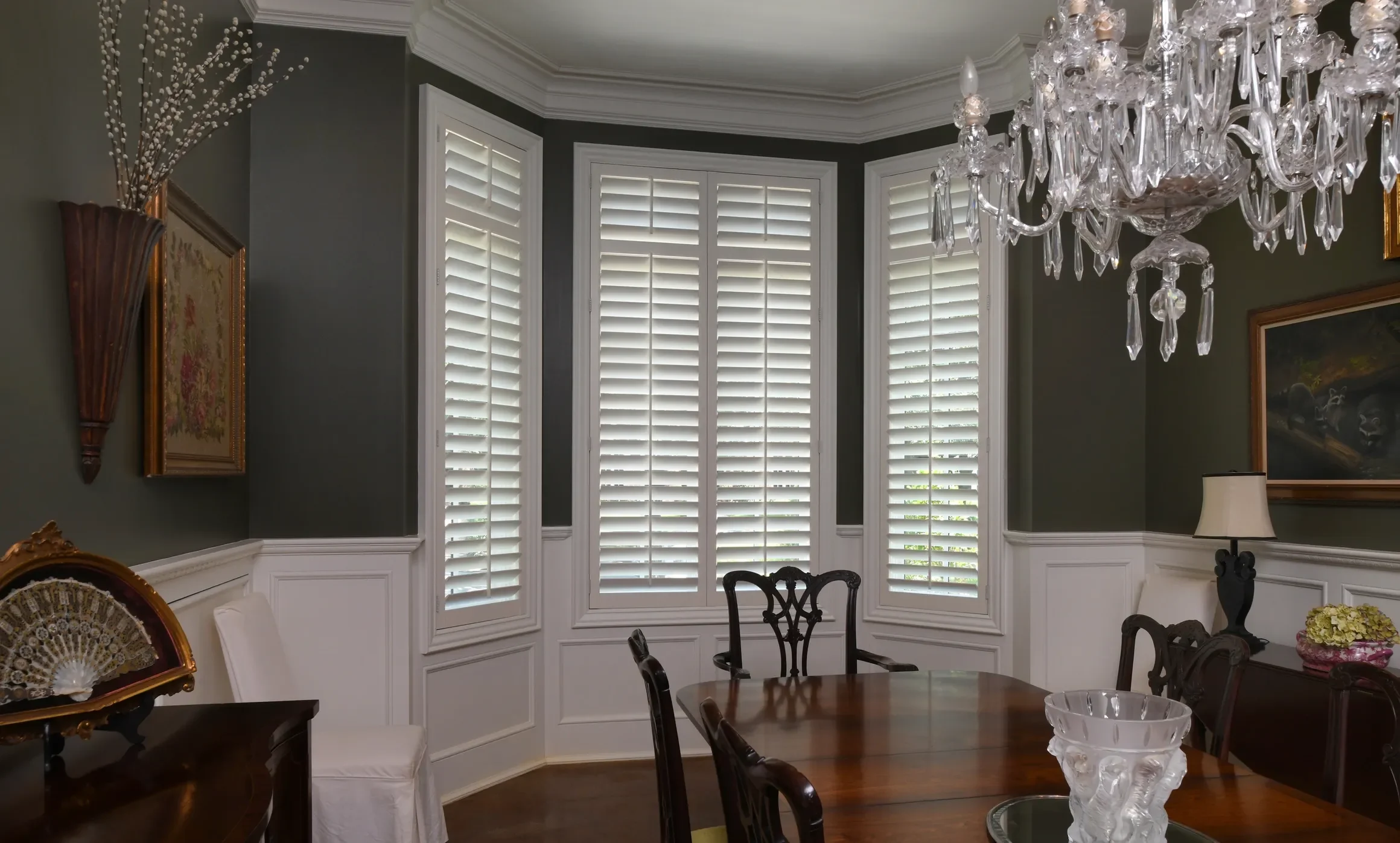 Custom wood shutters with traditional front tilt rod, divider rails at sash, 3 1/2" louvers, painted Sherwin Williams Extra White, painted white hinges.