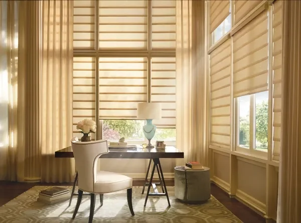 A room with large windows covered by Hunter Douglas Vignettes Roman Shades with PowerView motorization, 6"fold, light filtering fabric.