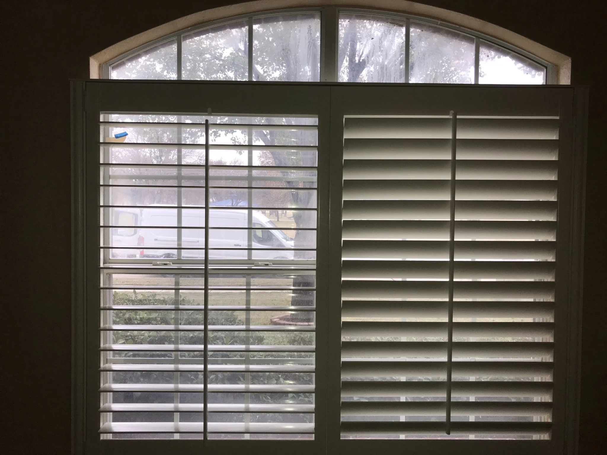 Painted white wood shutter with front tilt rod, no divider rail, 4 1/2" louvers.  Not covering arch.