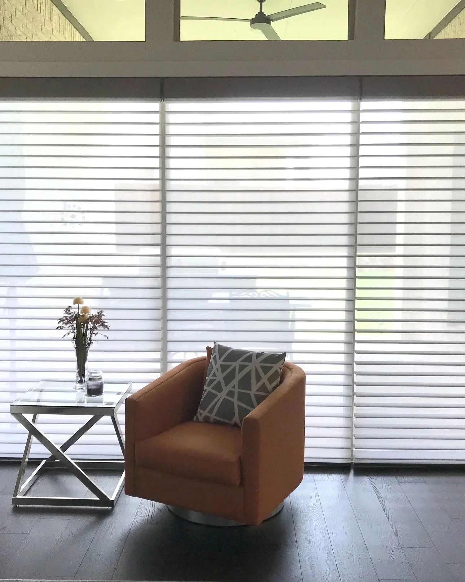 A cozy indoor seating area with Hunter Douglas Nantucket PowerView A Deux Shadings, Sankaty Merion, outside mount over sliding doors.
