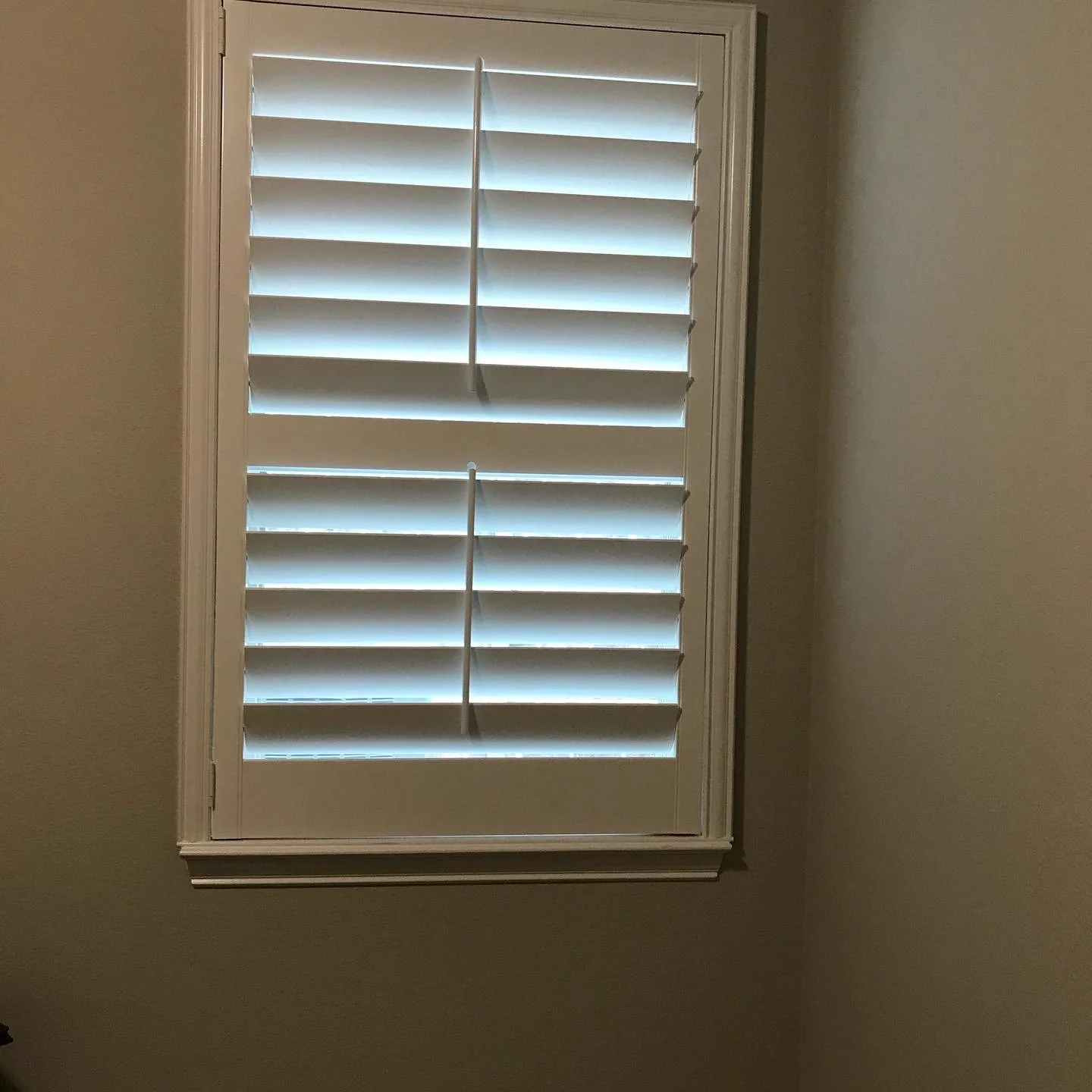 Custom painted wood shutters with front tilt rods, 4 1/2" louvers, divider rail at sash, painted white, 1 panel hinged left.