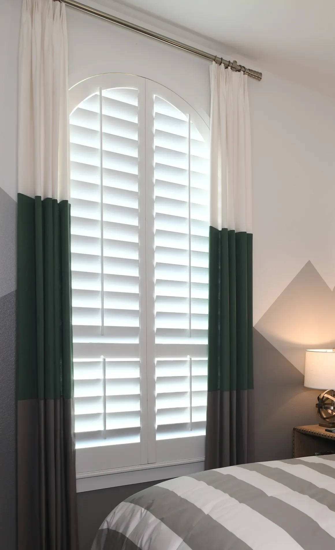 Custom wood shutters with traditional front tilt rod, divider rails at sash, 4 1/2" louvers, painted Sherwin Williams Extra White, painted white hinges.