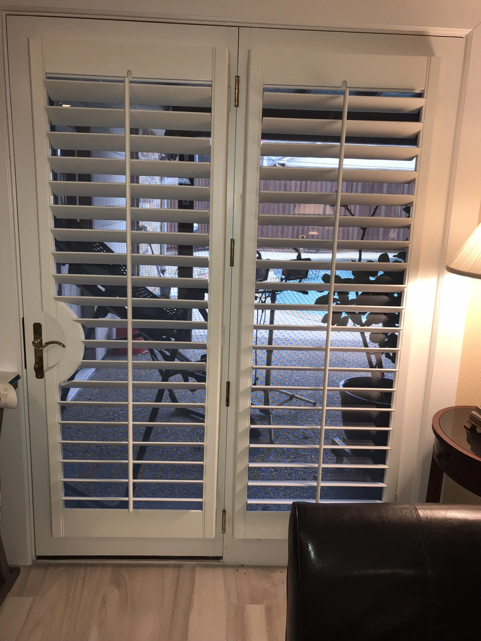 Custom wood shutters, 3 1/2" louvers, front tilt rod, outside mount frame, rounded door cutout, 1 panel each.  Open position.