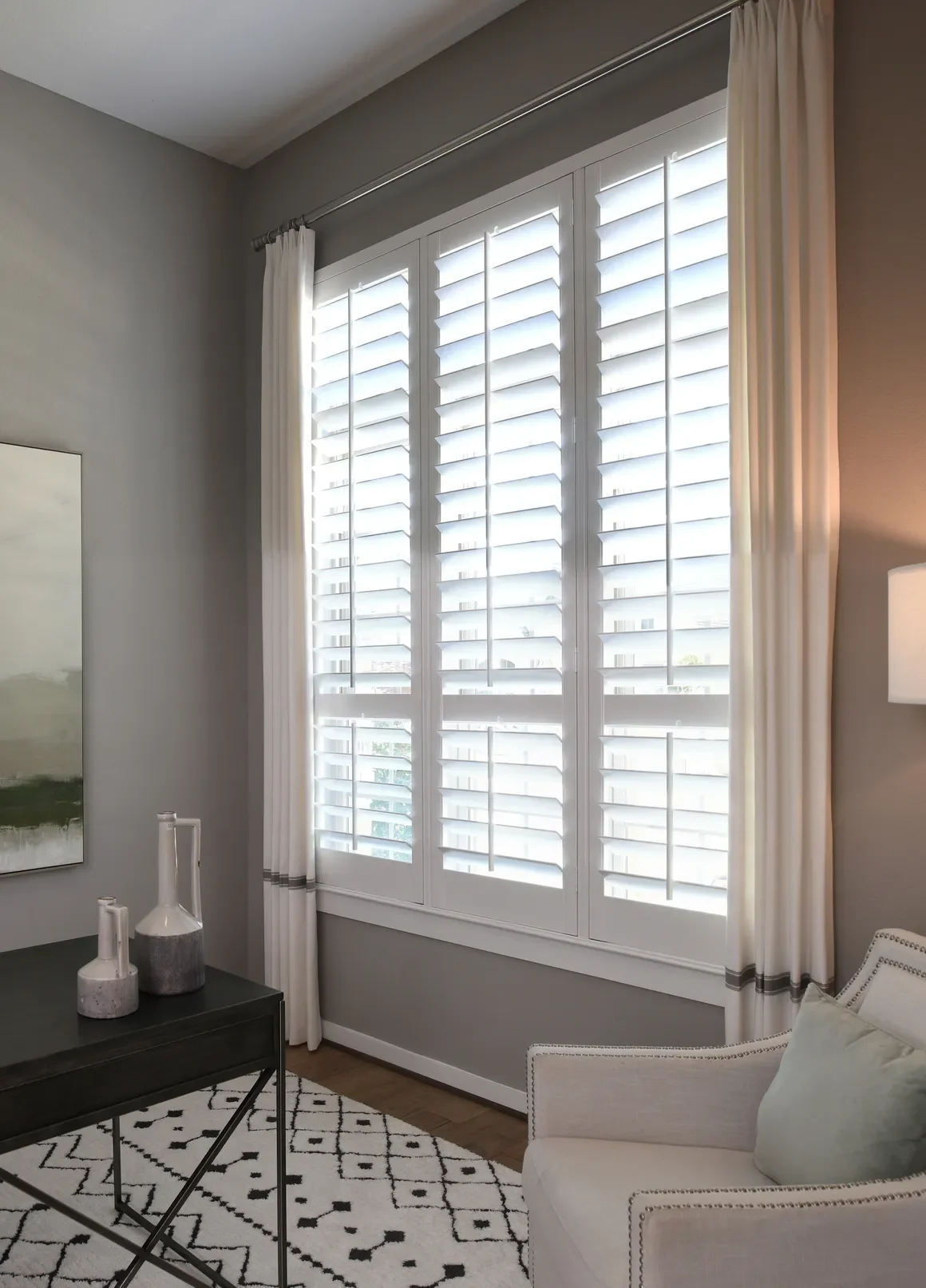 Custom wood shutters with traditional front tilt rod, divider rails at sash, 4 1/2" louvers, painted Sherwin Williams Extra White, painted white hinges.