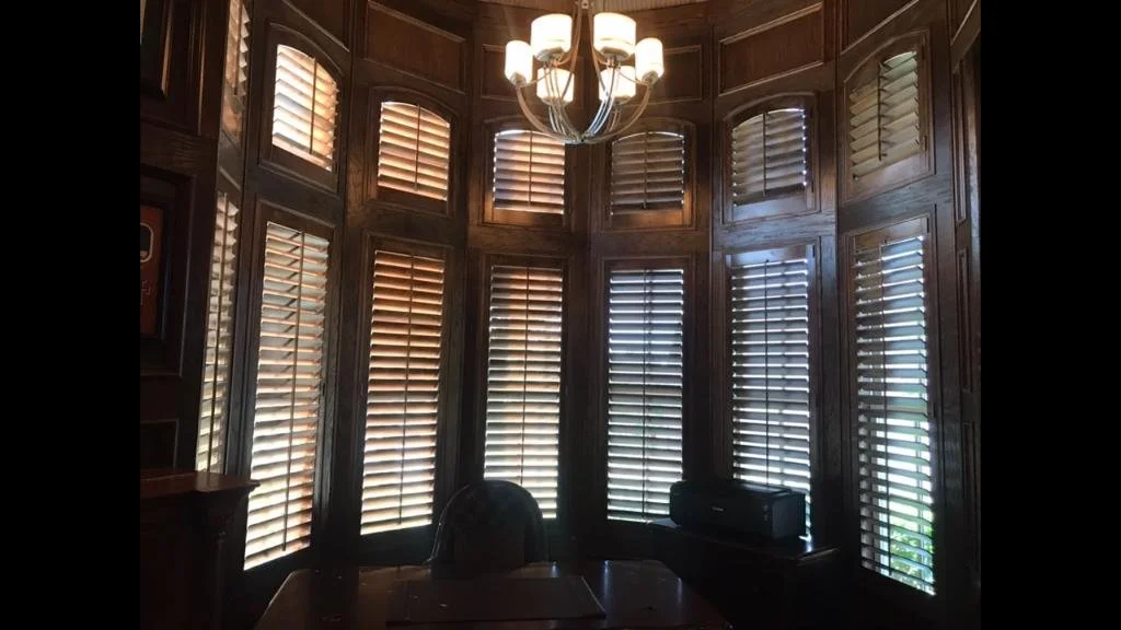 Custom stained wood shutters, 3 1/2" louvers, front tilt rod, custom stain to match wood trim, L frame, eyebrow arches on top.