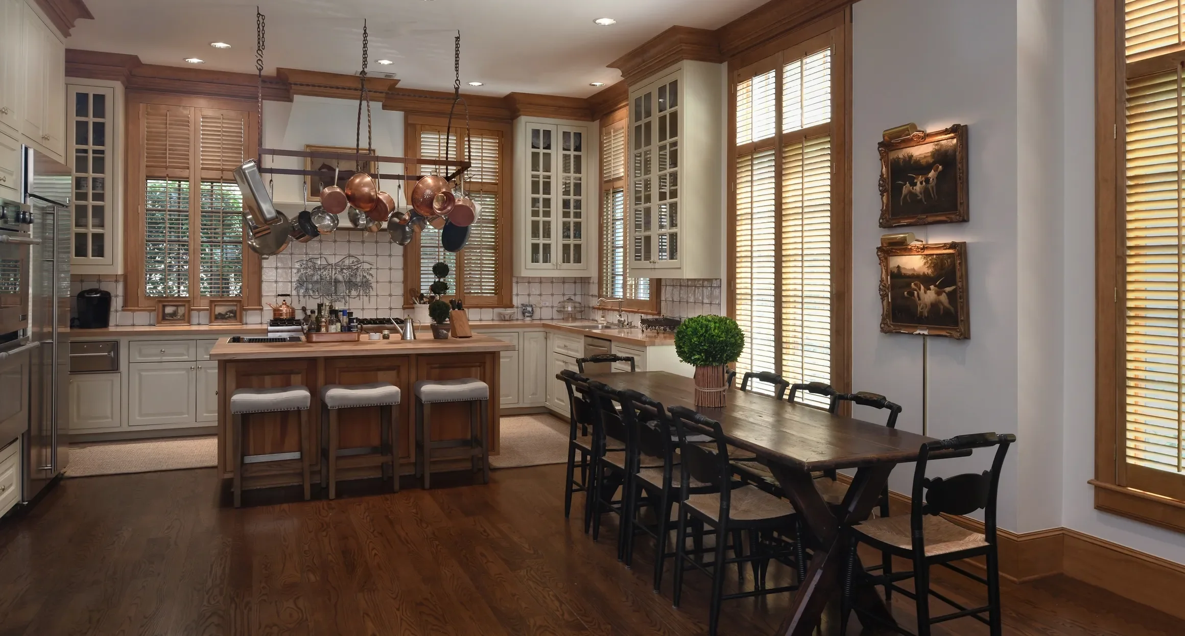 Custom stained wooden shutters stained to match wood trim, 2 1/2" louvers, front tilt rods, divider rails, antique brass hinges, 2 panels hinged left and right.