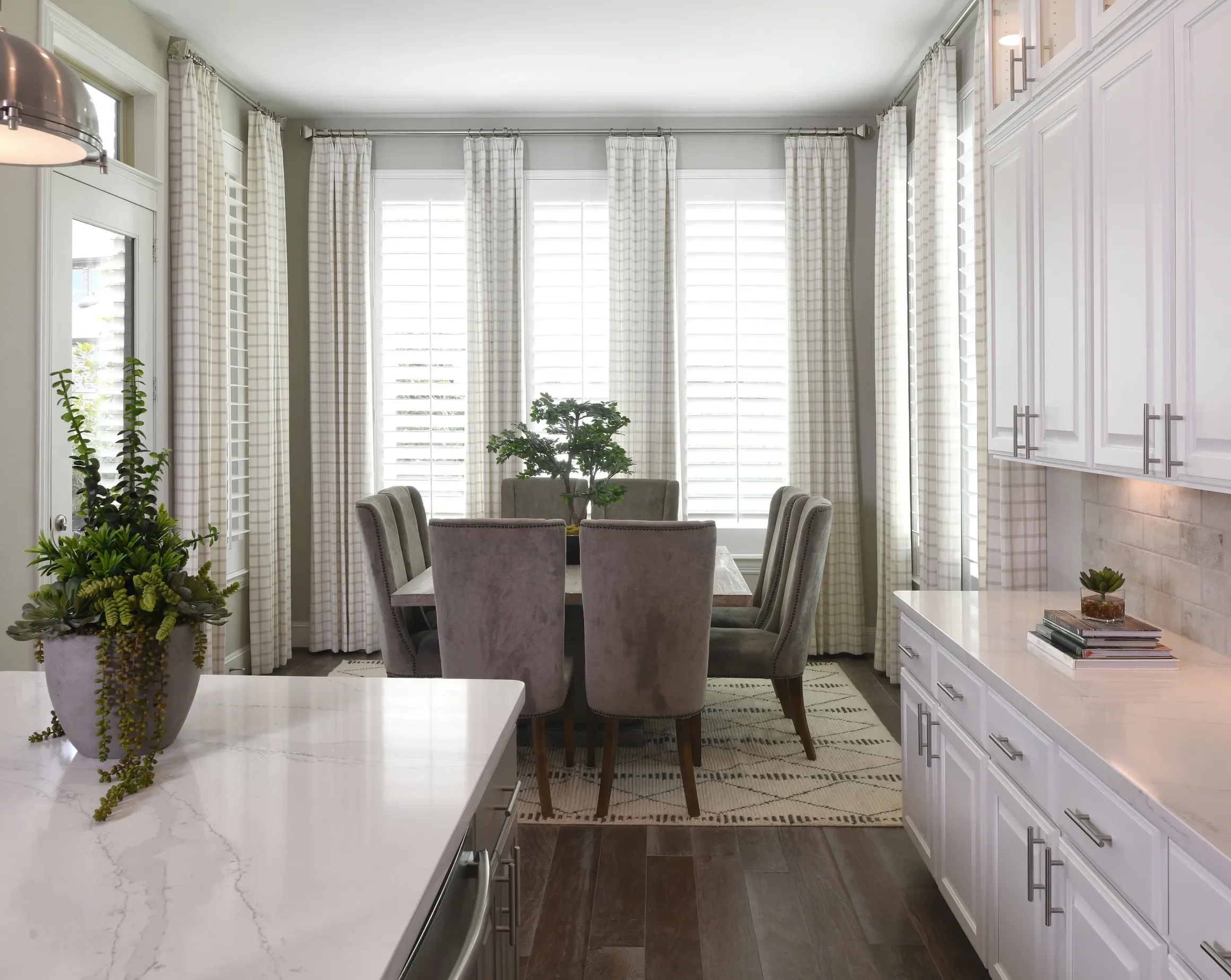 Custom wood shutters with traditional front tilt rod, divider rails at sash, 4 1/2" louvers, painted Sherwin Williams Extra White, painted white hinges.