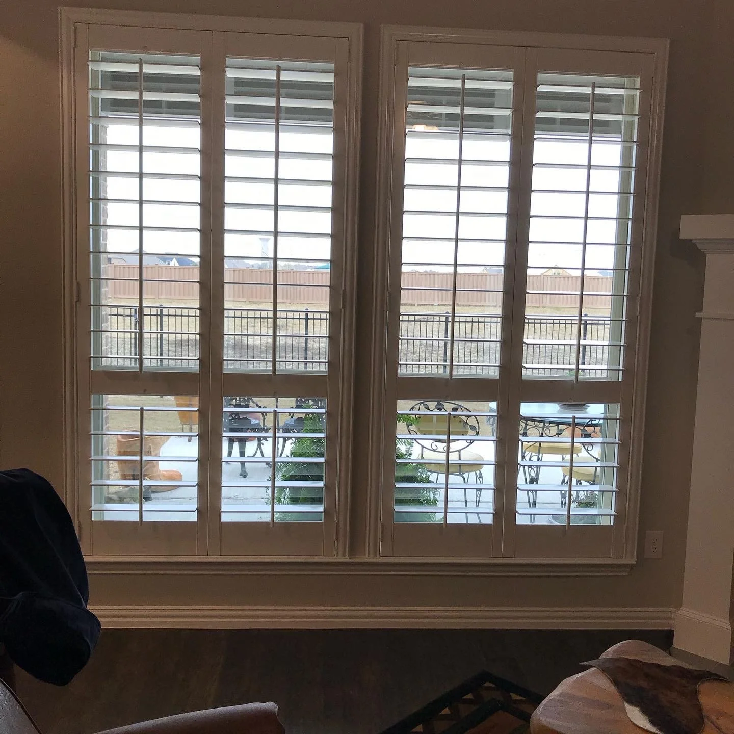 Custom painted wood shutters with front tilt rods, 4 1/2" louvers, divider rail at sash, painted white.  2 panels hinged left, right.