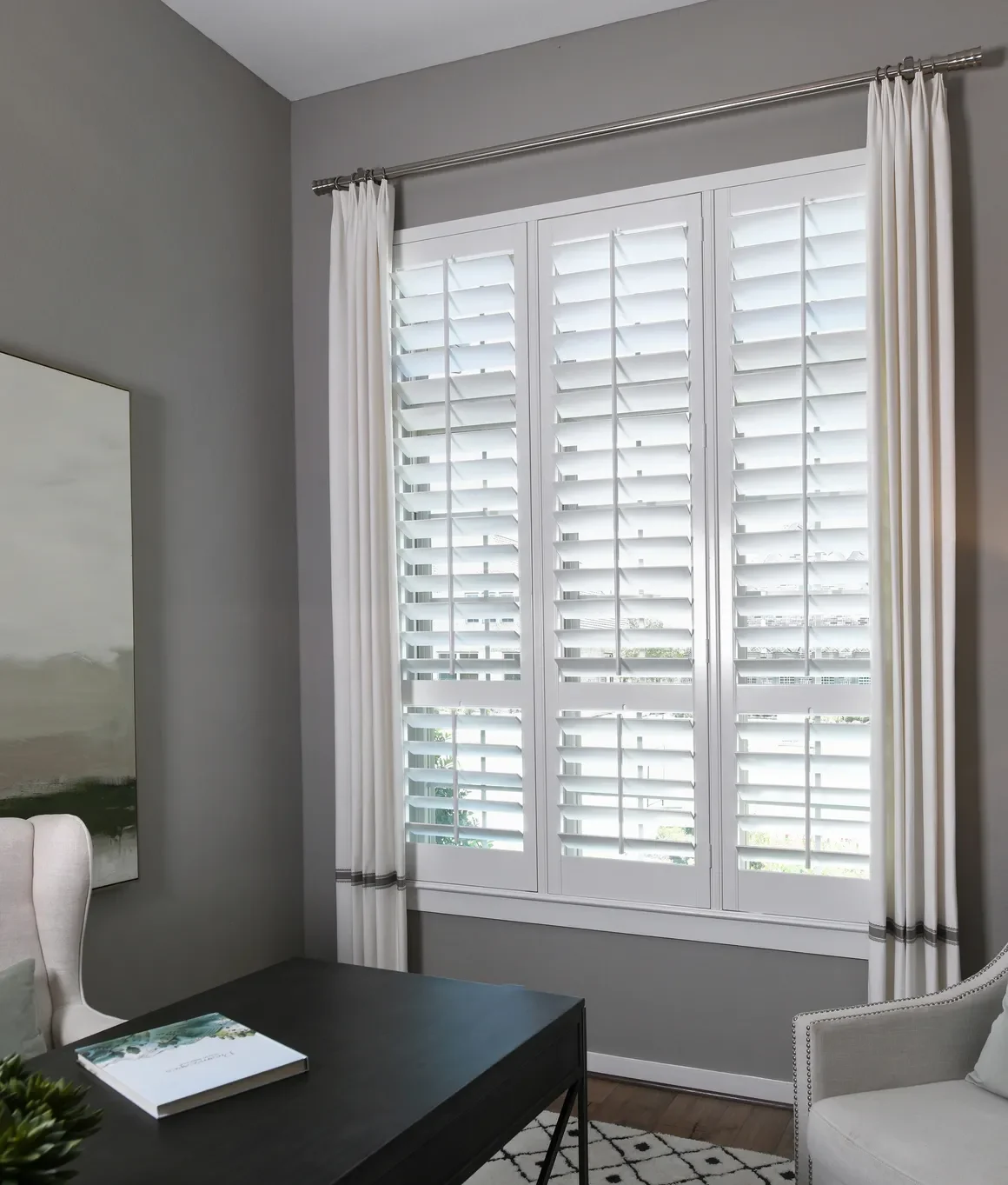 Custom wood shutters with traditional front tilt rod, divider rails at sash, 4 1/2" louvers, painted Sherwin Williams Extra White, painted white hinges.