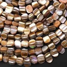 Close-up of multiple glass beads in various shades of brown and beige.