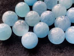 Multiple light blue plastic balls on a dark surface.