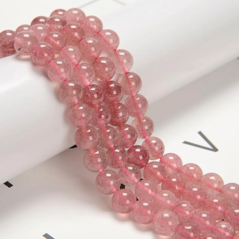 Close-up of a pink beaded necklace with multiple strands, resting on a white surface with black printed text.