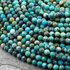 Pile of turquoise, blue, and green marbles on a gray surface.