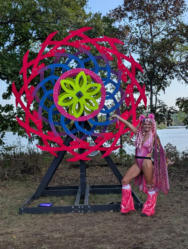Pink leopard festival look in front of a giant festival art sculpture