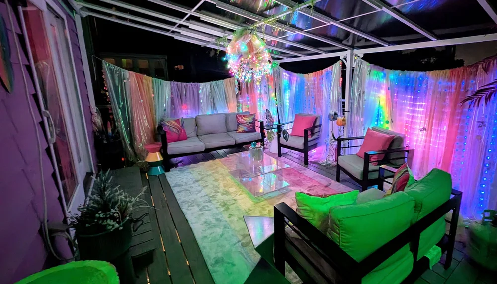Cabana at night with glowing curtain lights behind rainbow sheers