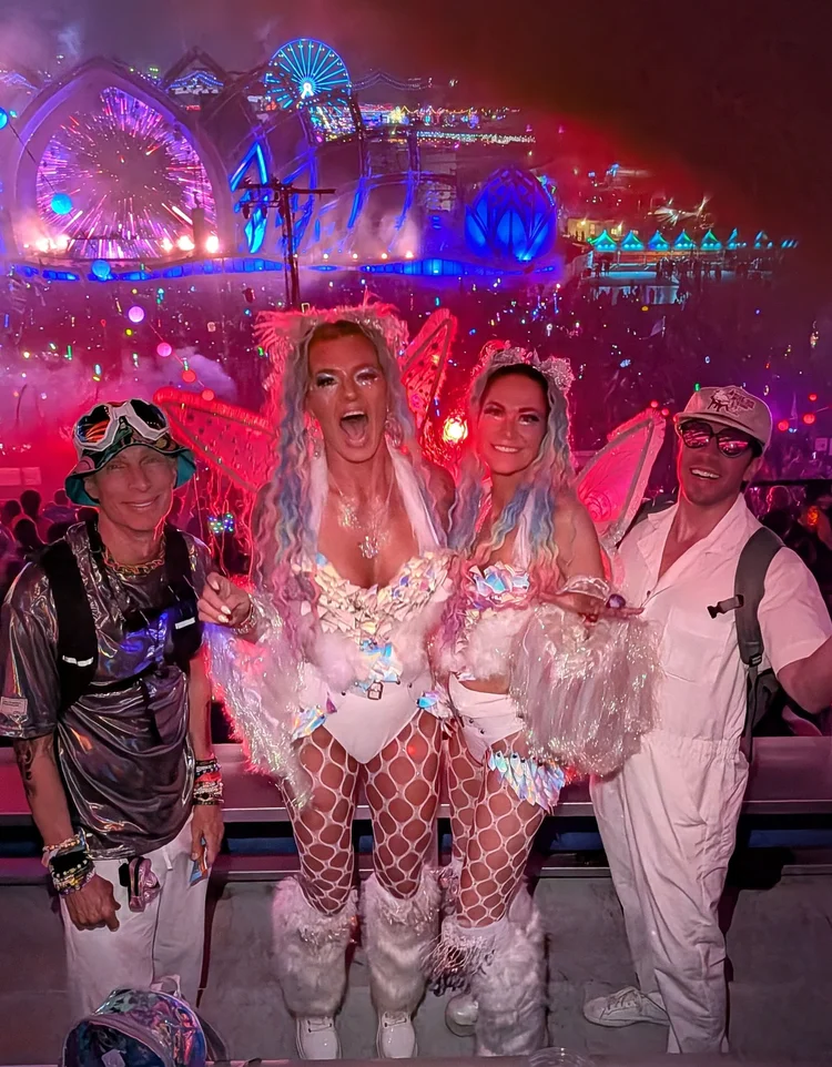 A festival crew in coordinated white and pink looks at night