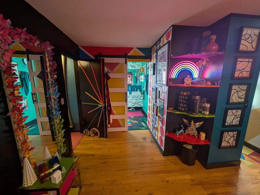 Hallway with a neon rainbow sign and barn doors