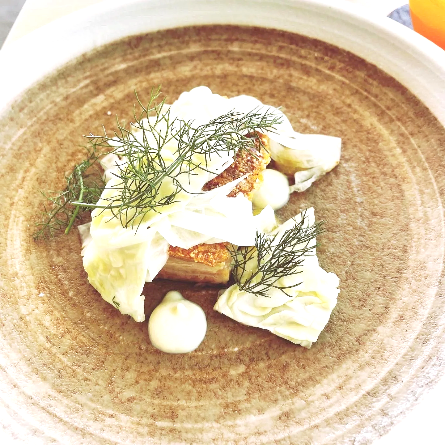 Crispy pork belly with braised cabbage, dill, daikon cream