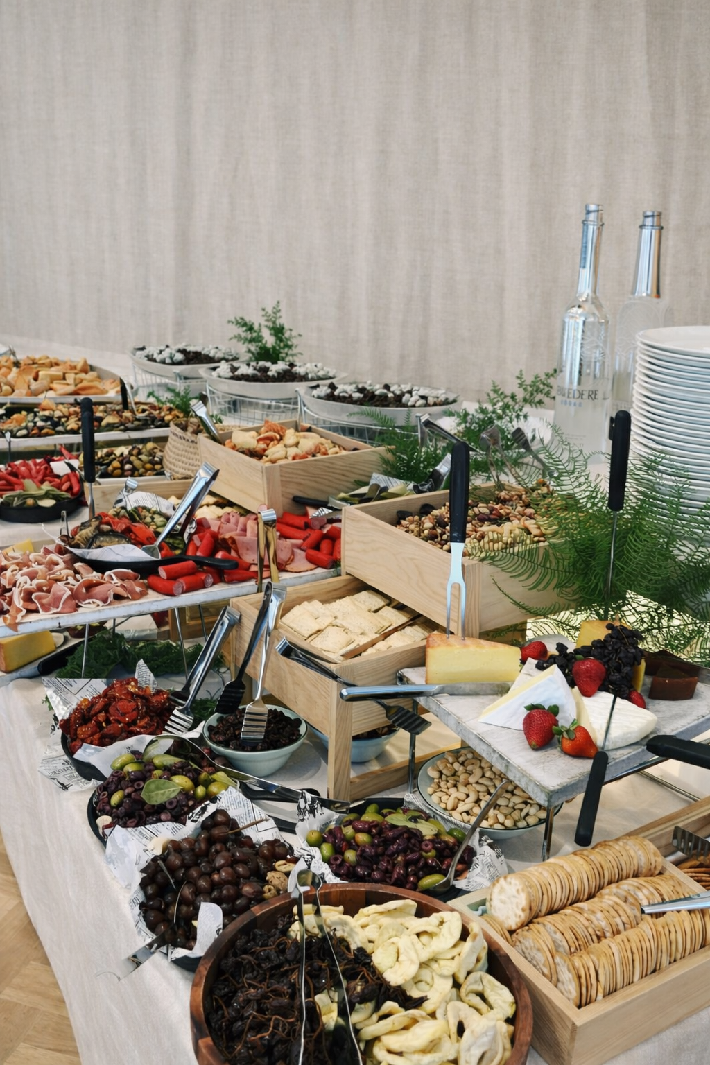 Cheese table with dried fruits, fresh fruits, crackers, nuts, set up for an event.