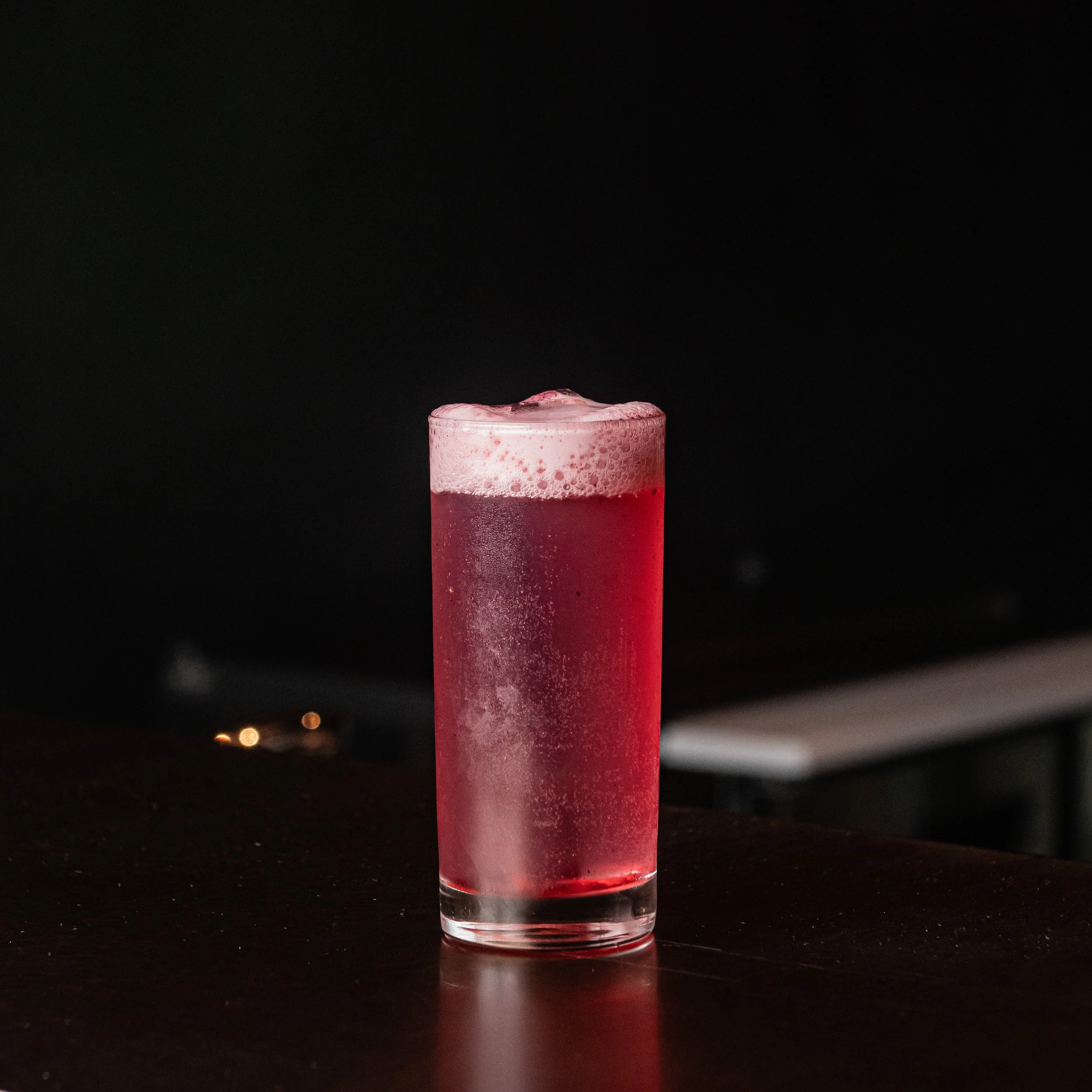 A Violet Tonic cocktail, topped with hibiscus foam.