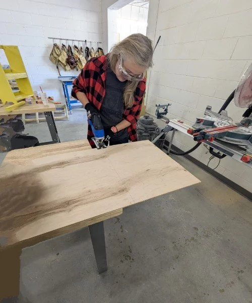 Drywall repair technician measuring and sawing drywall using power tools in Durham, NC