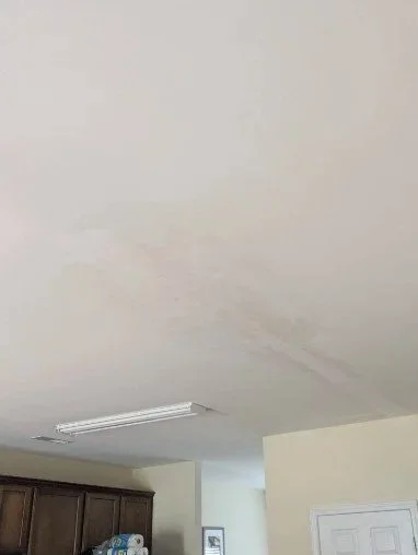 Kitchen ceiling drywall area around light fixture during repair process