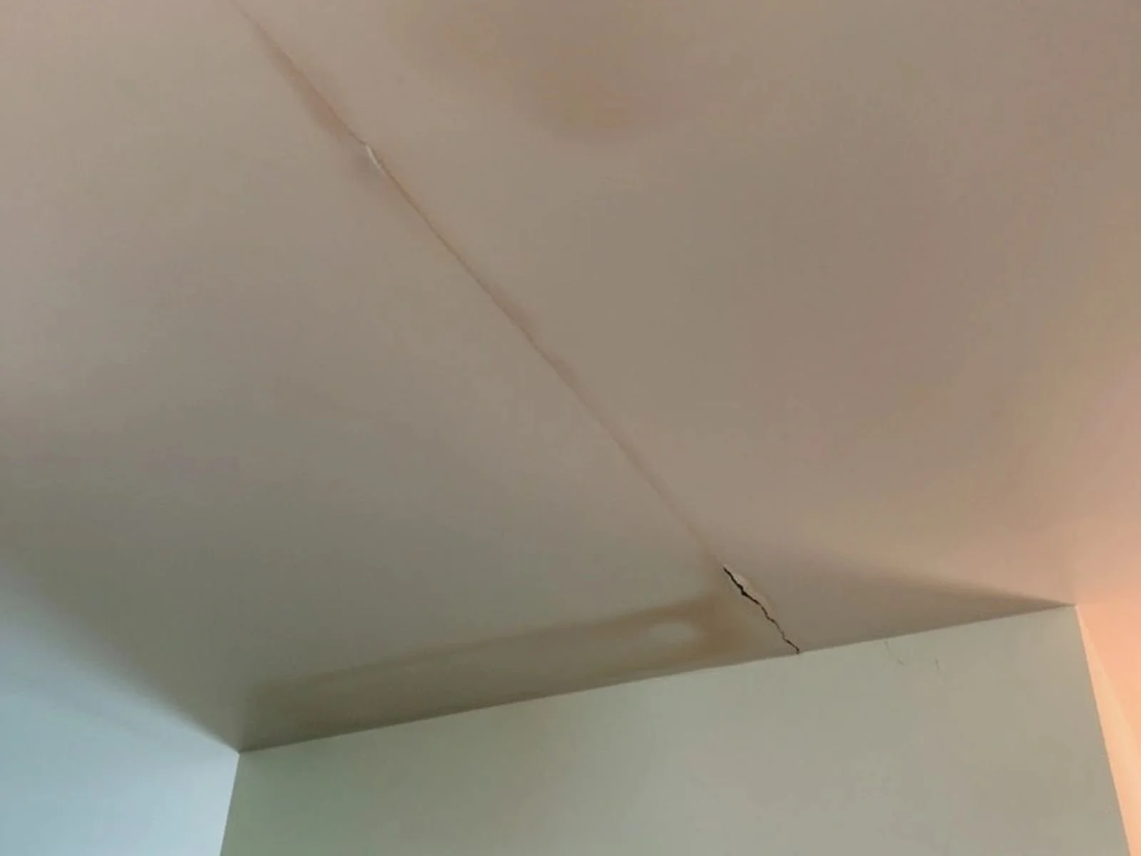 Kitchen ceiling with drywall crack with water damage before repair work begins in a Durham, NC home
